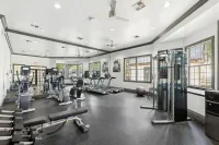 Bright and modern fitness center equipped with state-of-the-art exercise machines, large mirrors, and natural lighting Stonebriar at Frisco Apartments