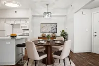 Inviting dining area with elegant round table, modern lighting, and a seamless connection to a contemporary kitchen.