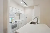 Bright, modern kitchen with sleek white cabinetry, elegant countertops, and stainless steel fixtures.