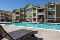Charming apartment complex with private balconies overlooking a pristine swimming pool, perfect for relaxation and leisure.