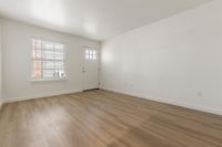 Bright and inviting living space with beautiful wood flooring and ample natural light from a large window.