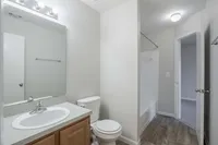 Experience elegance in this sleek modern bathroom, featuring stylish wooden cabinetry and a roomy shower.