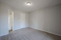 Step into comfort in this spacious and serene bedroom, complete with an inviting bathroom entrance.
