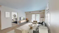 Bright and inviting living room with modern decor, plush sofas, and a large window letting in natural light, perfect for relaxation.