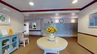 Inviting apartment lobby featuring a round table with vibrant sunflowers, cozy seating, and modern mailboxes.