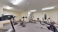 Modern fitness room equipped with treadmills, exercise bikes, and strength training machines, offering a perfect space for a healthy lifestyle.
