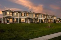 Exterior view of townhomes with lush landscaping during a beautiful sunset for rent in Apopka, Florida.