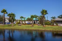 view of clubhouse from across lake in afternoon