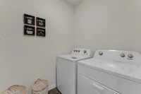 Spacious laundry room with full-size washer and dryer.