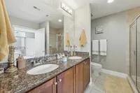Spacious bathroom featuring double vanity, granite countertops, and walk-in glass shower