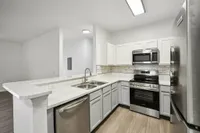 interior pic of deluxe kitchen unit with gray planking and white walls, stainless steel appliances and backsplash