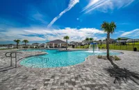 Expansive community pool with splash features and open-air seating.