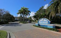Inviting entrance to Bridgewater at Lake Osborne with palm trees and a sunny, welcoming atmosphere.