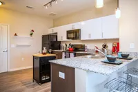 Contemporary kitchen with granite countertops, sleek cabinetry, and modern appliances.