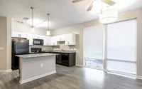 Modern kitchen with sleek granite countertops, contemporary lighting, and abundant natural light from large windows.