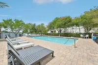 Inviting outdoor pool area with comfortable loungers, surrounded by lush greenery and serene views.