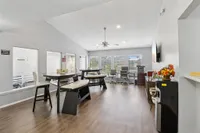 Bright and modern community room with sleek furniture, large windows, and stylish wood flooring, perfect for gatherings.