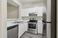 Modern kitchen with sleek stainless steel appliances, elegant white cabinetry, and polished countertops.