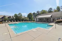 Inviting outdoor pool area with crystal-clear water, surrounded by comfortable seating and lush greenery.