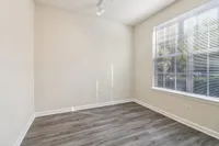 Bright room with sleek hardwood floors and large window offering ample natural light.