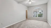 Bright and airy bedroom with plush carpet, large window showcasing scenic views, and a convenient walk-in closet.