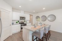 Chic modern kitchen with granite countertops, elegant bar seating, and sleek stainless steel appliances.