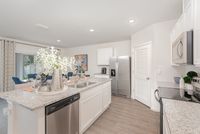 Bright and modern kitchen with sleek granite countertops, stainless steel appliances, and an elegant dining area in a stylish open-concept layout.