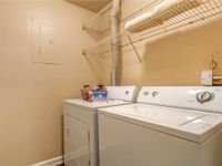Spacious laundry room, with full-size washer and dryer. Two racks of over-laundry storage