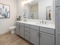 Spacious bathroom, double vanity sinks, linen cabinet