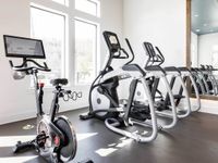 Bright fitness center, cardio station with stationary bike and ellipticals