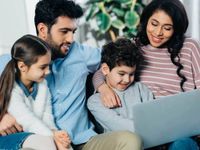 cheerful family looking at laptop at fern park apartments