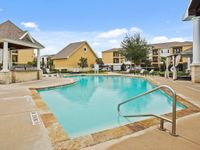 Inviting community pool surrounded by cozy homes and lush greenery.