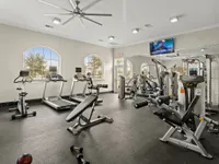 Spacious fitness center with modern equipment including treadmills and strength machines.