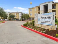 Inviting exterior view of Advenir at Grand Parkway West Apartments, showcasing landscaped grounds and modern architecture.