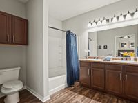 Inviting bathroom with dual sinks, modern cabinetry, and a sleek shower curtain.