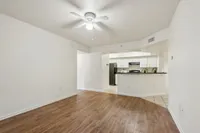 Bright and airy apartment interior with modern kitchen, sleek cabinetry, and elegant wood flooring.