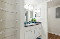 Bright and modern bathroom with sleek vanity, ample shelving, and elegant lighting, ideal for a stylish home.