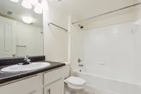 Elegant bathroom with a spacious white bathtub, modern fixtures, and a sleek countertop sink.