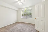 Bright and airy bedroom with plush carpet, large window allowing natural light, and fresh neutral walls, perfect for relaxation.