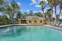 Inviting swimming pool surrounded by palm trees and sun loungers, perfect for relaxation in a tranquil environment.