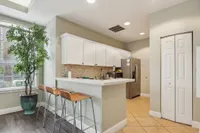 Bright and inviting kitchen with sleek white cabinets, a stylish tile backsplash, and a cozy breakfast bar with modern bar stools.