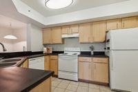 Modern kitchen with sleek black countertops, wooden cabinetry, and integrated appliances in a stylish apartment setting.