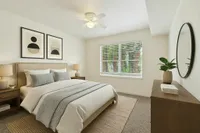 Serene bedroom with elegant decor, featuring a cozy bed, modern artwork, and a bright window view.