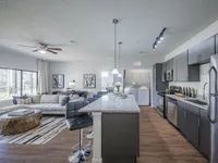 Modern open-concept apartment with sleek kitchen, spacious living room, stylish decor, and ample natural light.