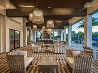 Luxurious outdoor lounge area with elegant wicker seating, ambient lighting, and scenic poolside views, perfect for relaxation and social gatherings.
