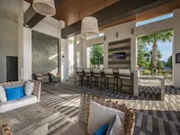 Chic outdoor lounge area with modern seating, stylish bar, and lush greenery, perfect for relaxation and entertaining.