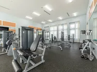 Bright and spacious fitness center with modern exercise equipment and large windows for natural light.