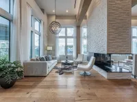 Luxurious open living area with elegant furnishings, modern fireplace, and floor-to-ceiling windows offering abundant natural light.
