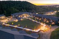 Stunning aerial view of a beautiful apartment complex nestled in nature, featuring modern buildings, well-lit pathways, and serene green spaces perfect for relaxation.