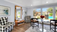 Chic lounge area with modern decor, large windows overlooking a stunning pool and landscaped courtyard, perfect for relaxation and socializing.